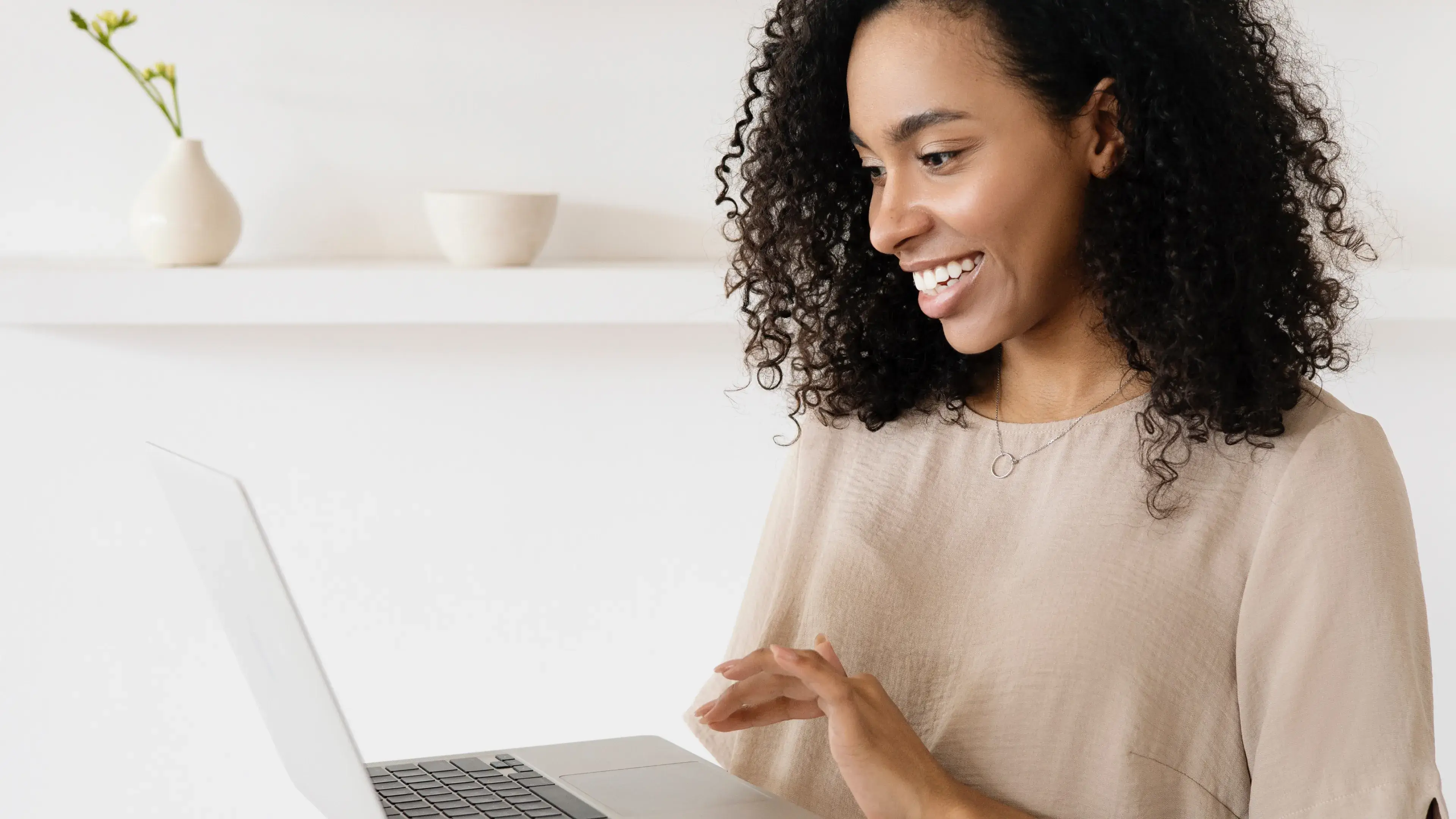 woman smiling while holding computer