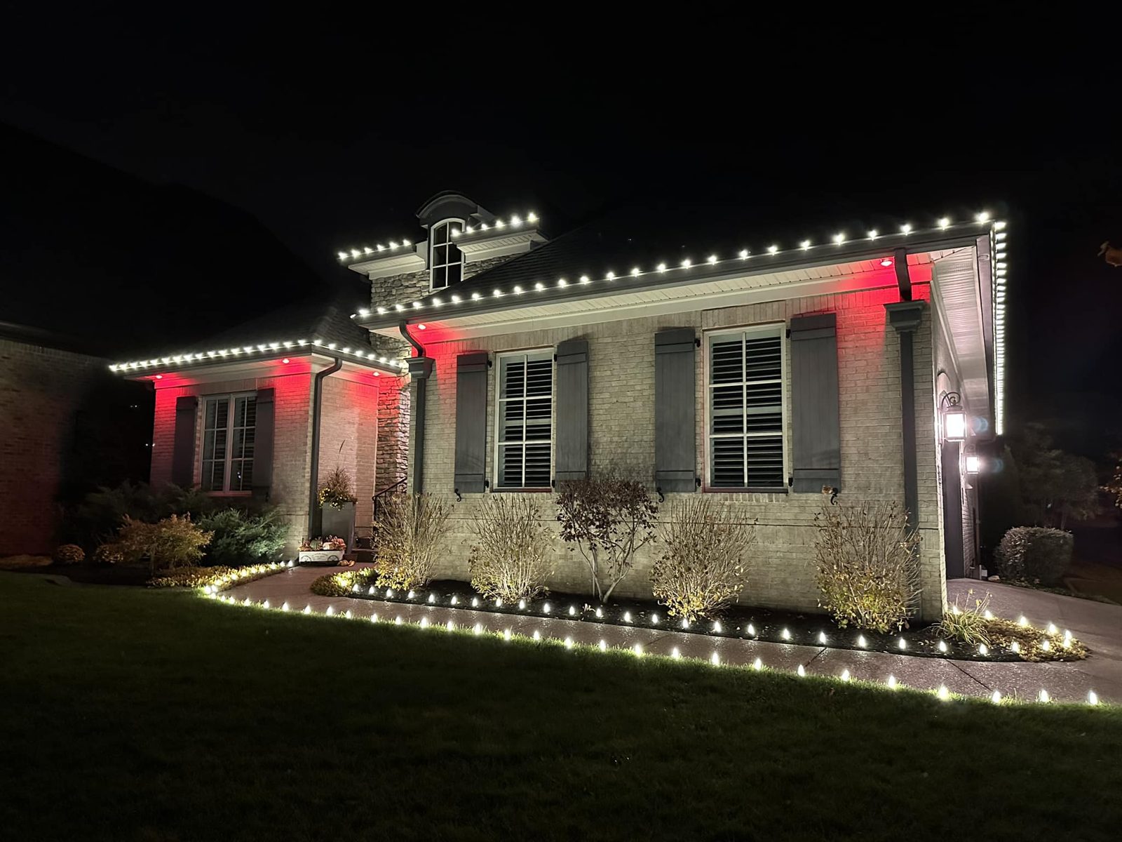 Home with warm white roofline and red accent lighting