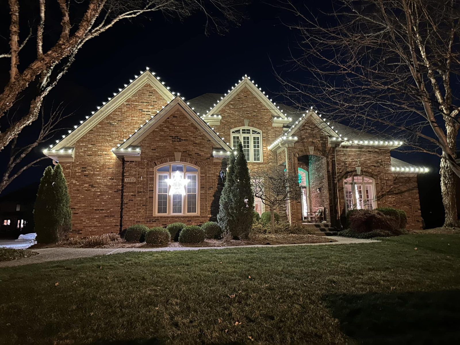 Brick home with warm white roofline lights