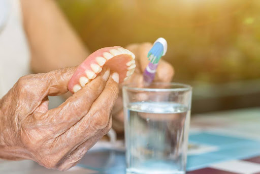 woman properly cleans her dentures
