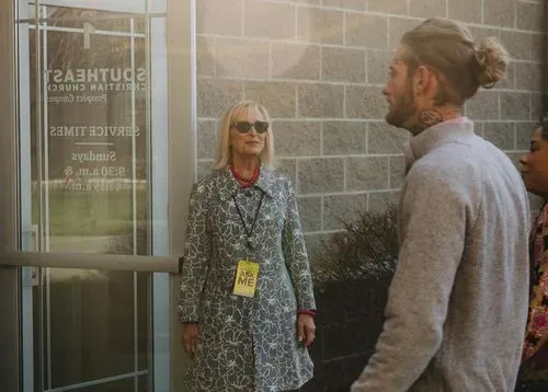 Greeter with 'Ask Me' badge welcoming attendees at Southeast Christian Church.