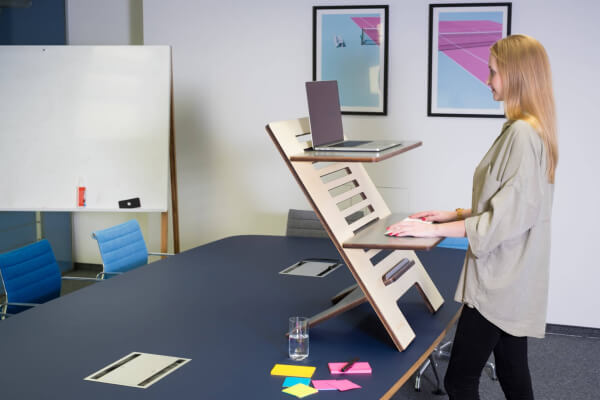 woman in white dress shirt standing near black table