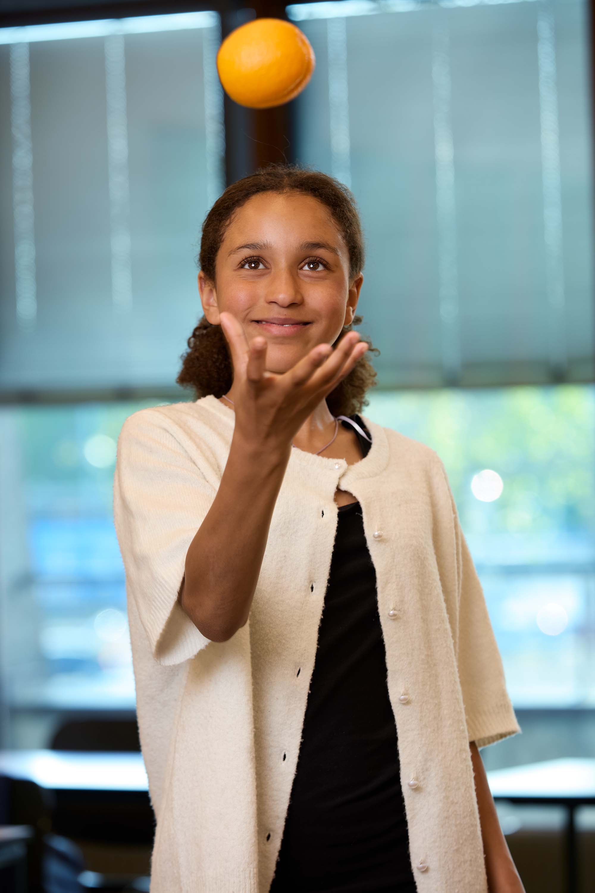 Bilde av en Skolefrukt-elev som kaster en applsin i luften