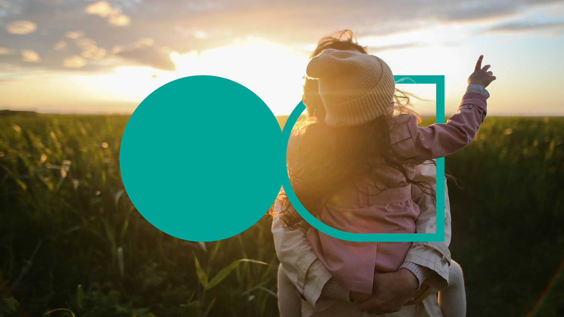 Barn på rygg til foresatt på et jorde som ser på soloppgang