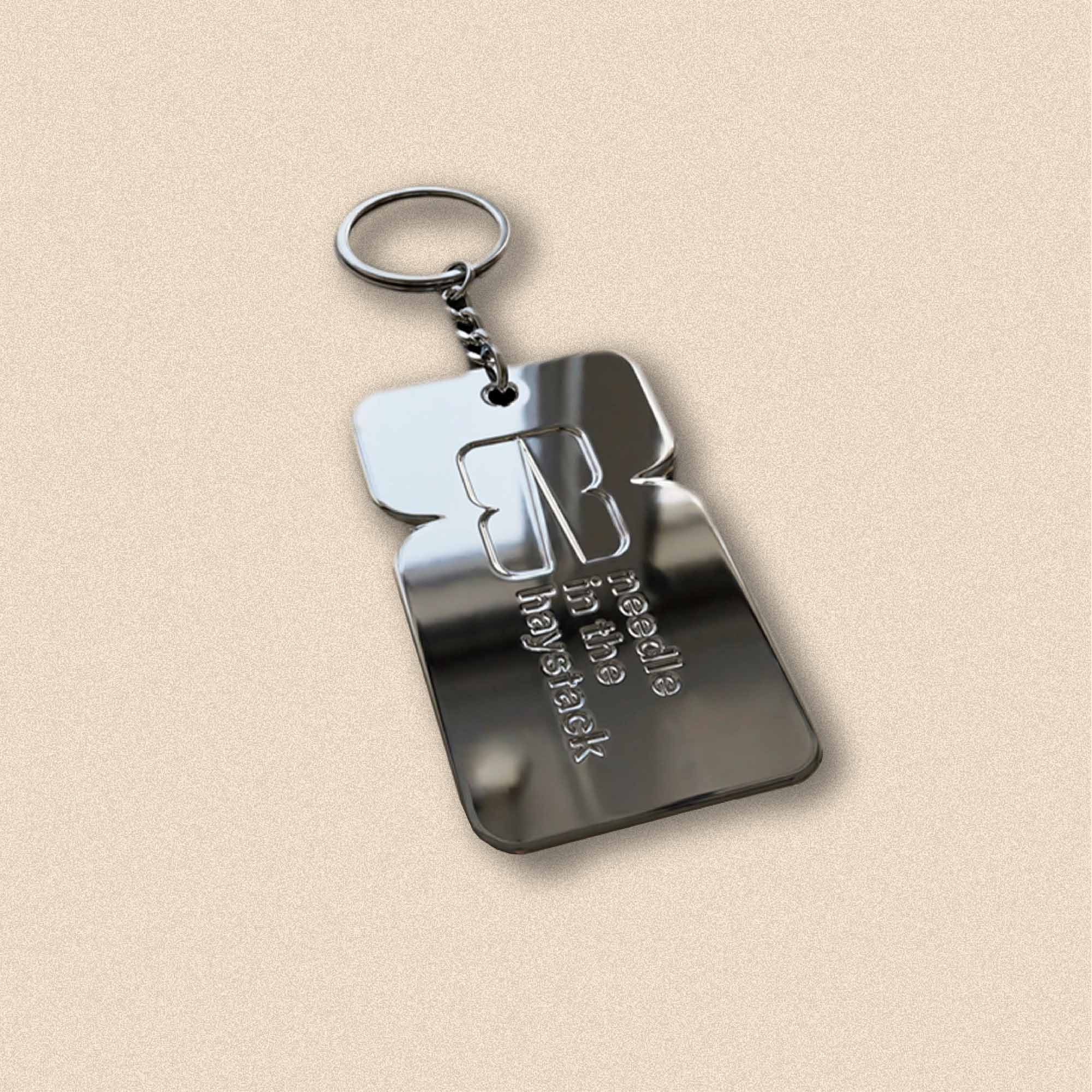 Eksempelbilde som viser Needle logo inngravert i sølvnøkkelring.