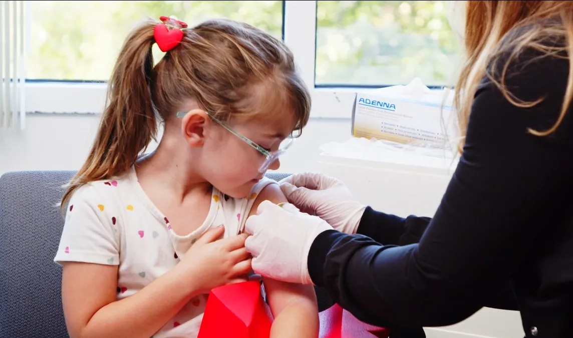 Little girl getting a shot while holding The Heart Spongie