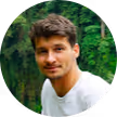 young_man_green_trees_background_dark_hair_looking_left_white_t-shirt_deeded_google_review