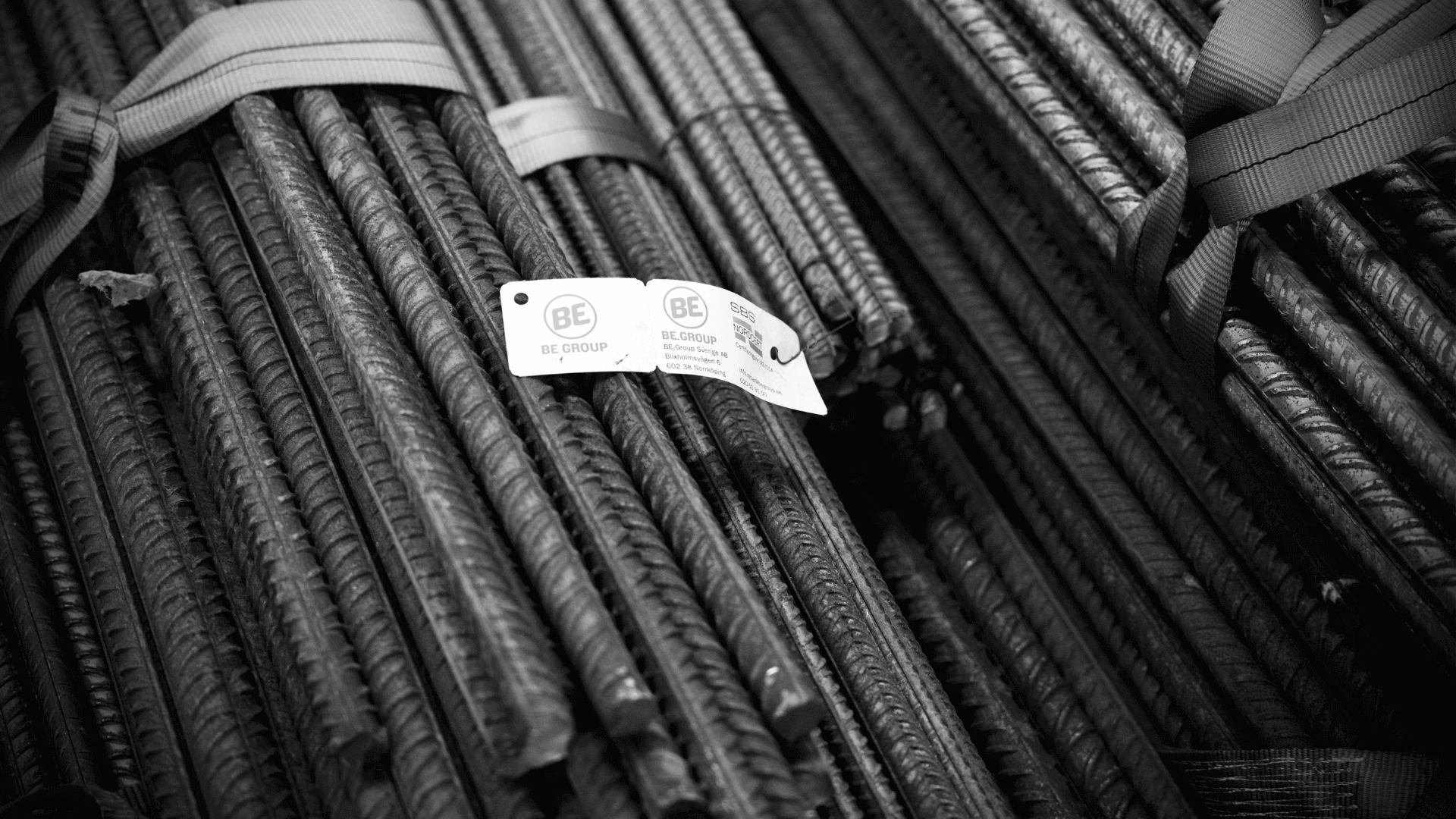 Close-up of bundles of steel rebars labeled with BE Group tags, representing traceable and sustainable steel production.