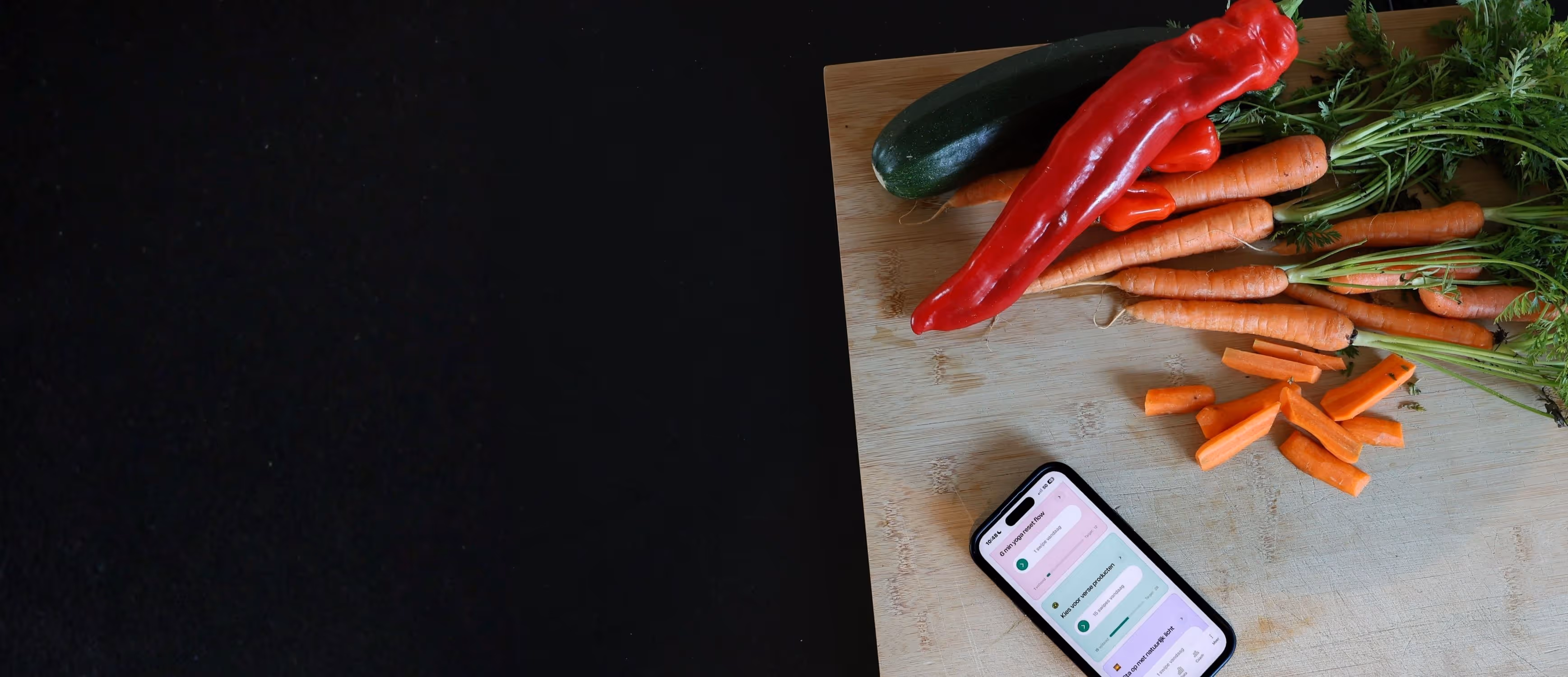 Vrouw snijdt groenten terwijl de Yoboo app met de actie “kies voor verse producten” naast haar open staat.