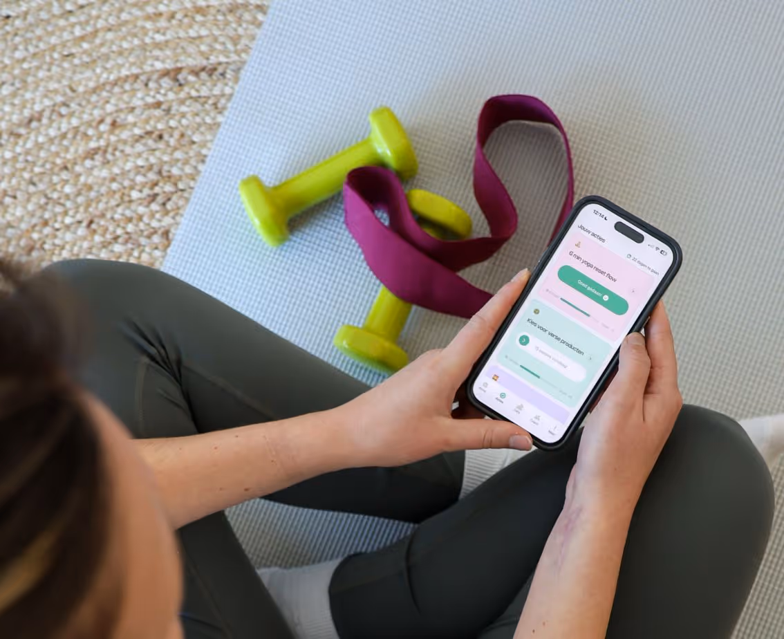 Femme sur un tapis de yoga avec des haltères tenant l’application Yoboo.