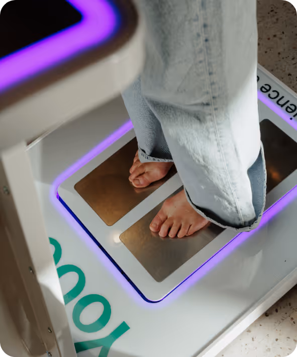 Voeten van een persoon zonder schoenen die op metalen platen staat van een toekomstig scanningsapparaat.