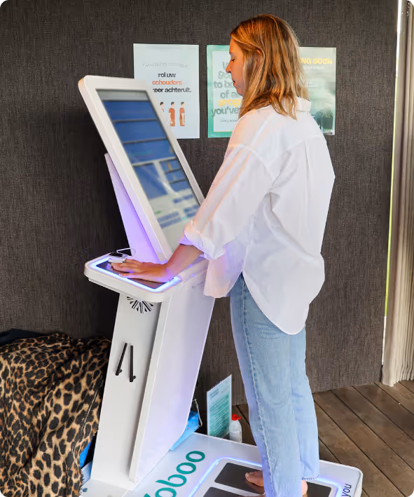 Vrouw staat op een Multiscan met handpalmen op de sensor, interactief scherm zichtbaar.