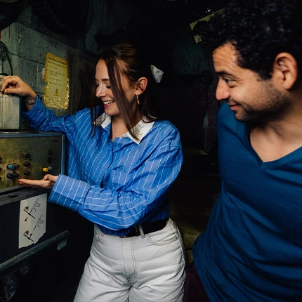 Ein Paar löst gemeinsam knifflige Rätsel in einem stimmungsvollen Escape Room von EXIT Berlin – ideal für ein besonderes Date zu zweit.