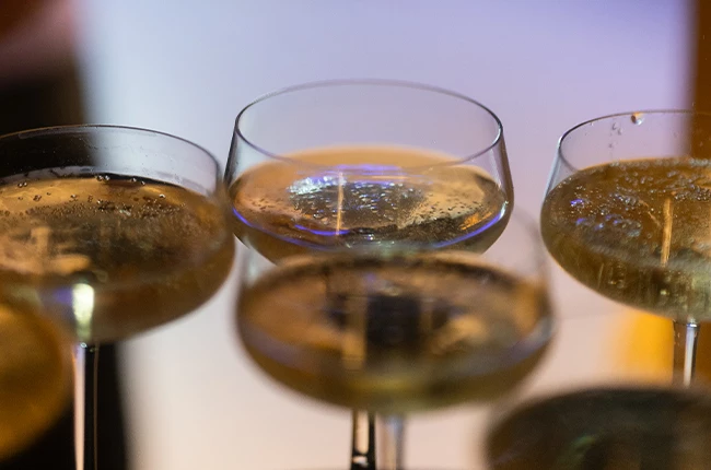 Festliche Weihnachtsfeier bei EXIT® Berlin: Kollegen stoßen im weihnachtlich dekorierten Foyer im Admiralspalast auf ein erfolgreiches Jahr an.