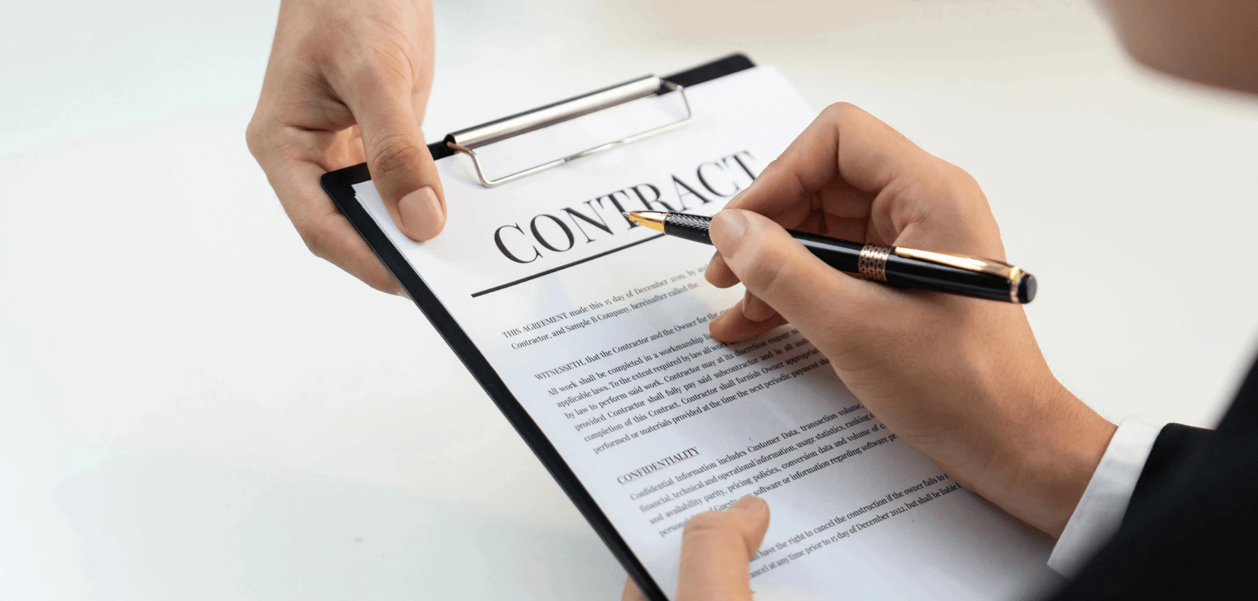 Signing an addendum contract on clipboard.