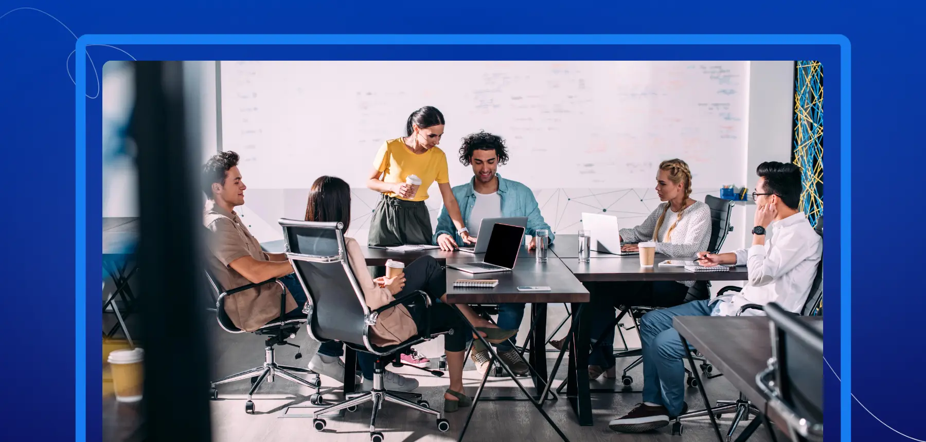 Office team reviewing documents on laptops, symbolizing adoption of e-signature solutions and digital business workflows.