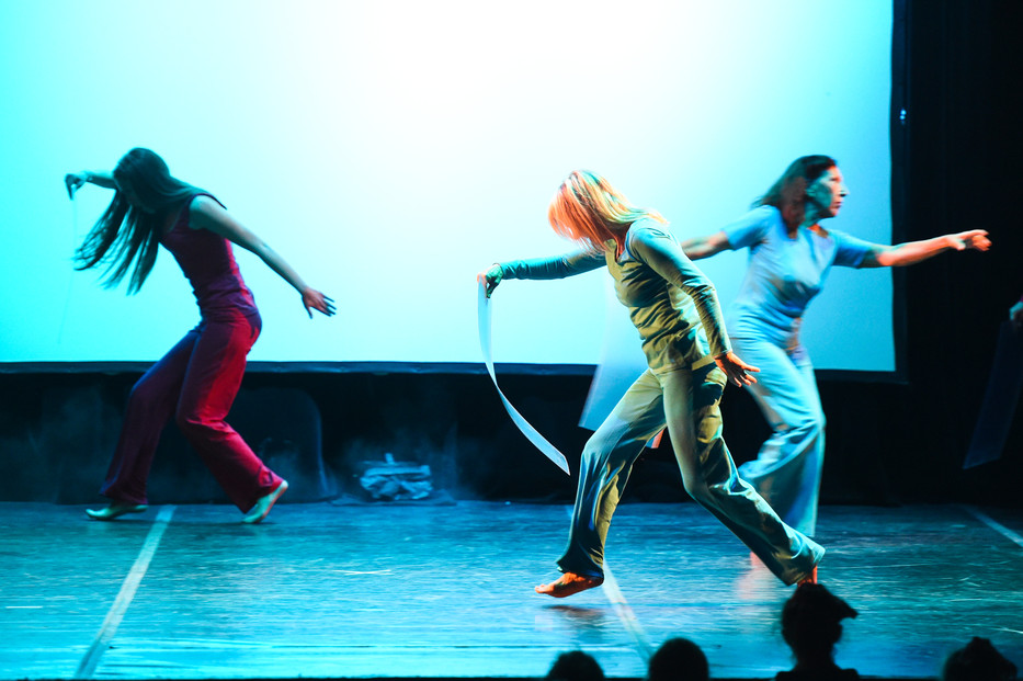 Spettacolo Oggidanza con danzatrici in movimento su sfondo blu