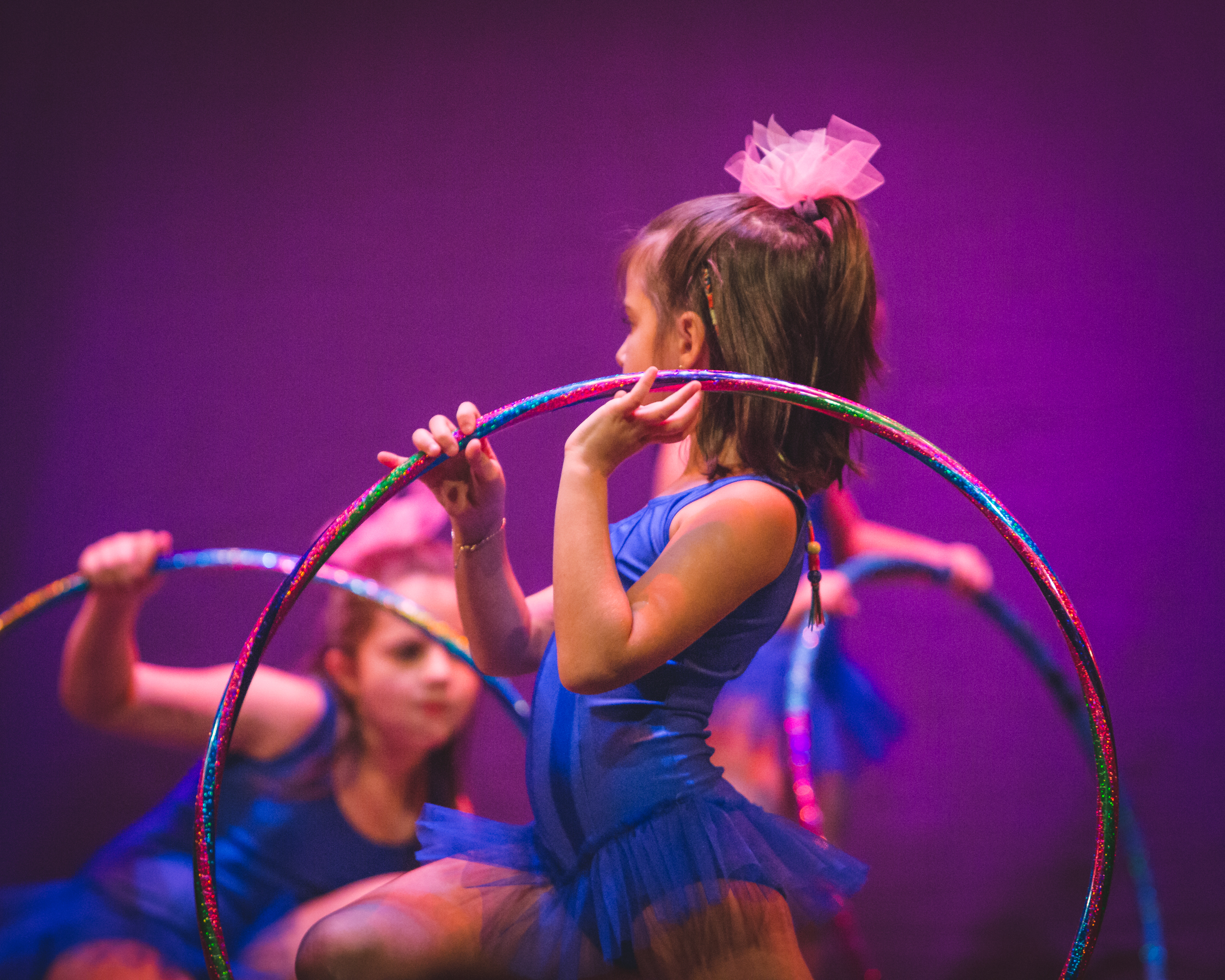Esibizione di gruppo di danza con allieve in costumi lilla sul palco
