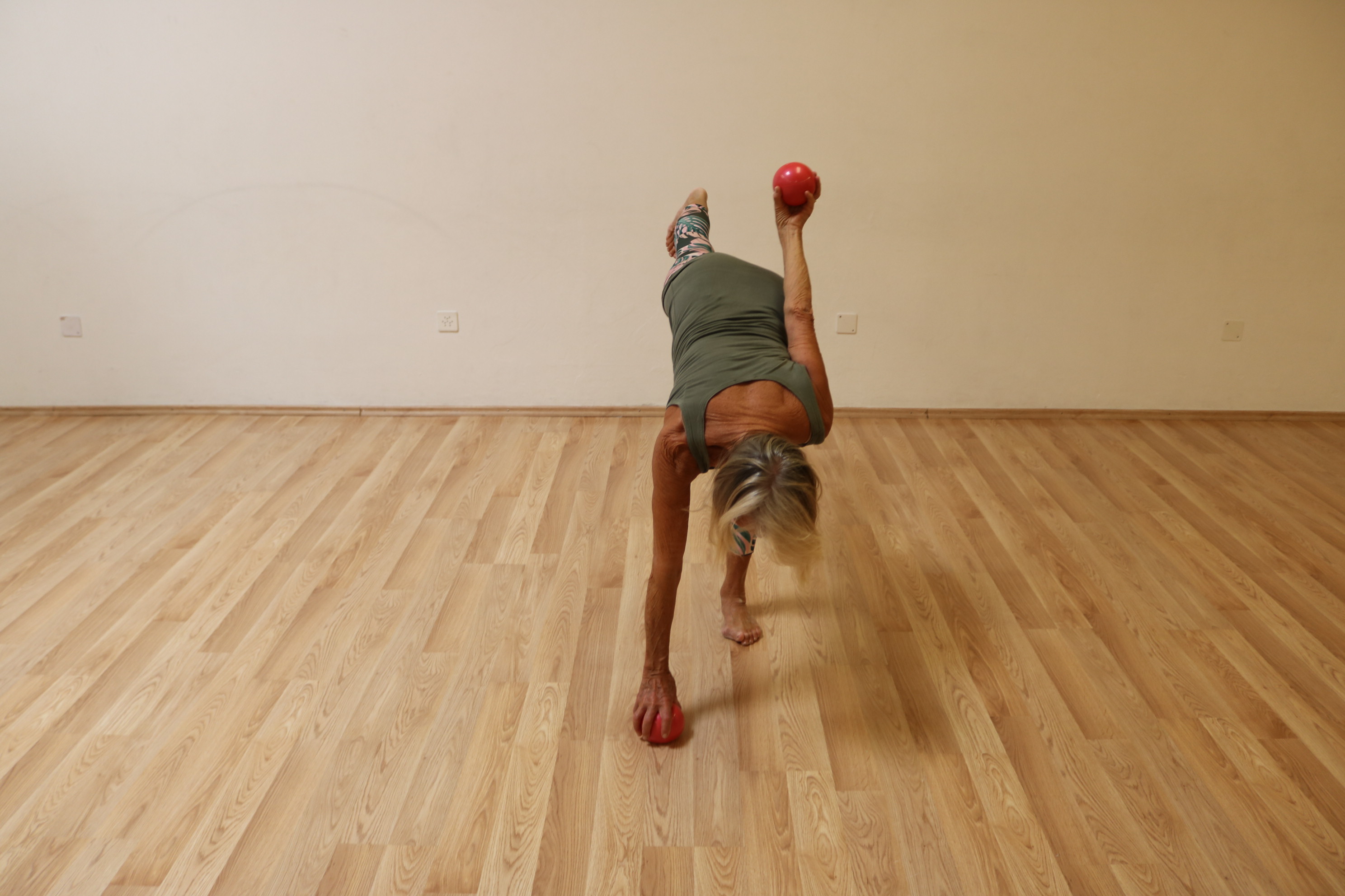 Insegnante esegue esercizio dimostrativo con pesetti rossi