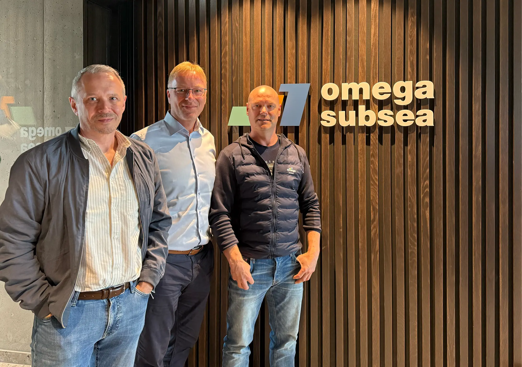 Kjell Eirik Jakobsen, Kurt Roar Vilhelmsen and Morten Haugen standing in front of the Omega Subsea logo.