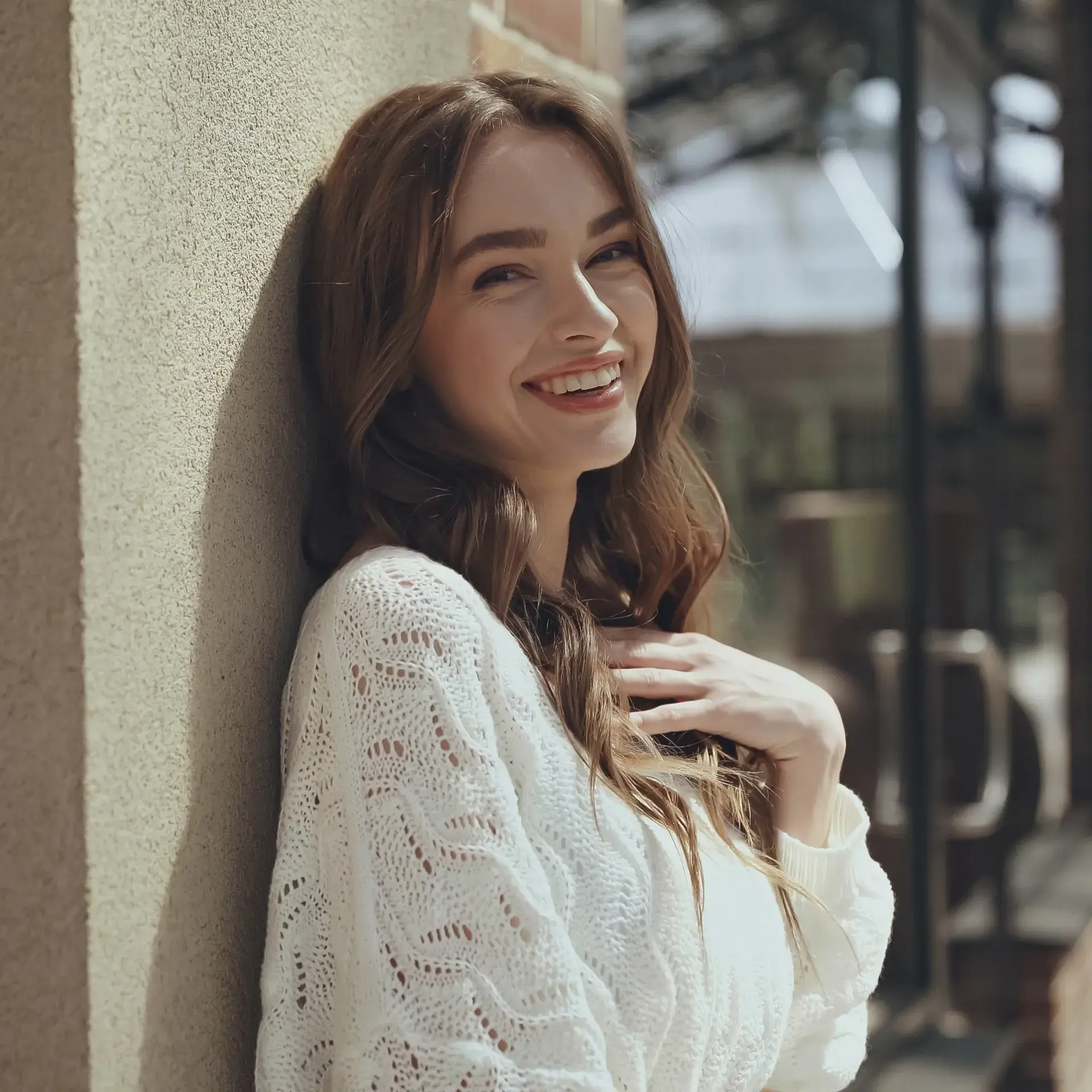 a woman leaning against a wall and smiling