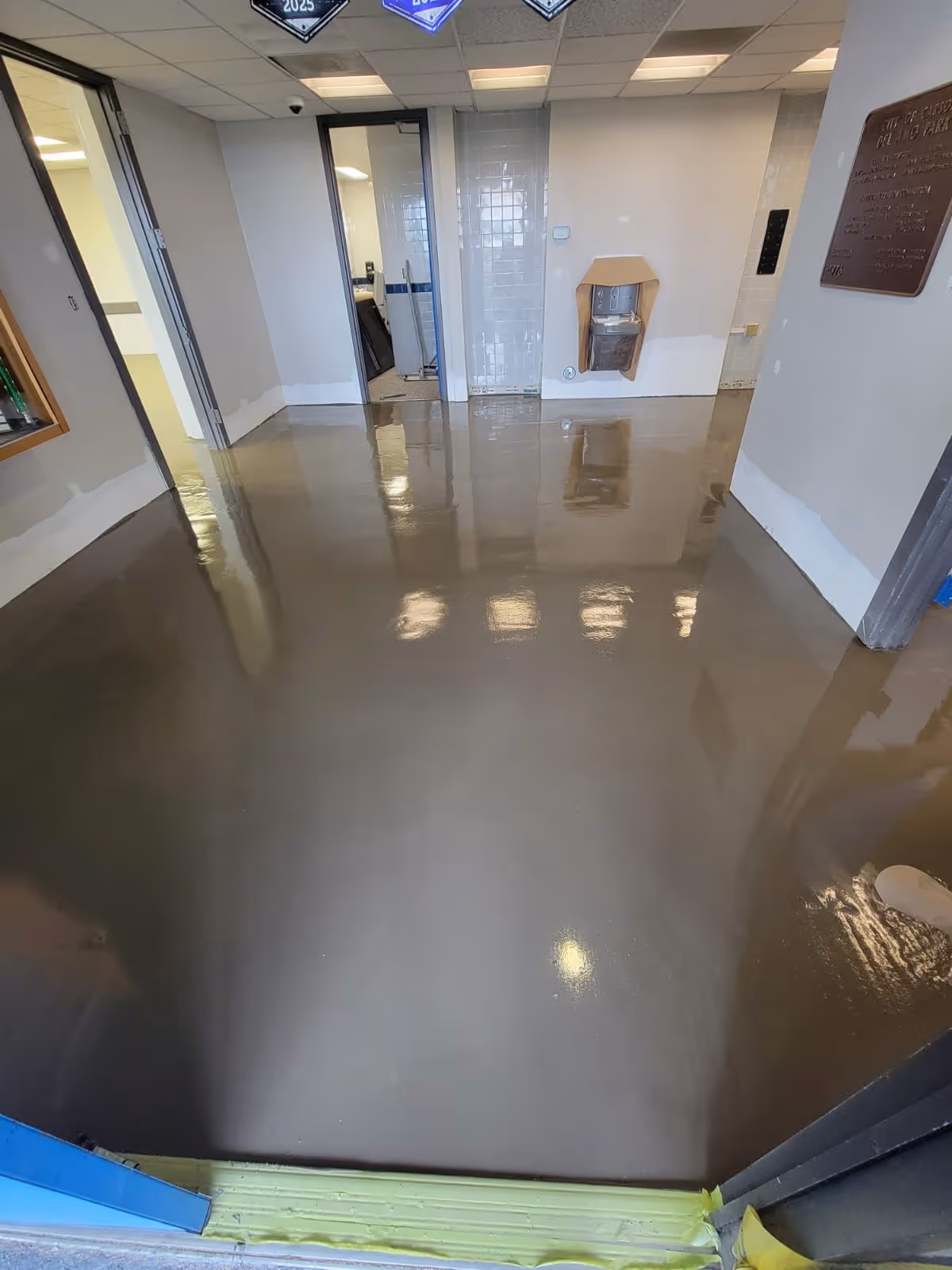 Indoor room with freshly poured and smooth shiny self-leveling floor under construction.