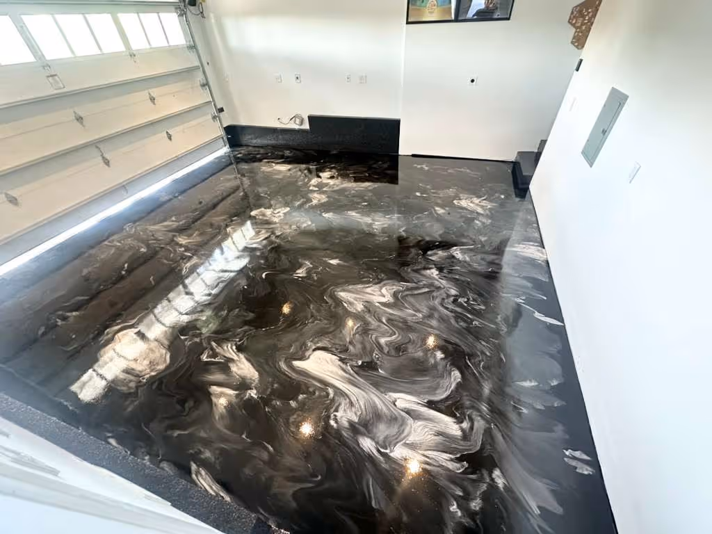 Garage interior with a glossy black and silver metallic epoxy floor and white walls.