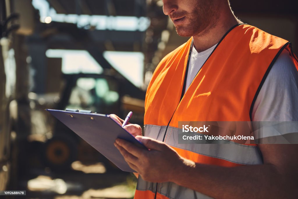 Mechanic responsibly refilling fluids, mindful of GMG's hazardous material protocols