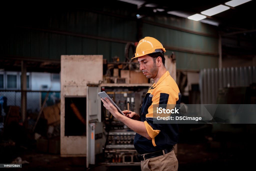 Workers holding helmets discuss GMG EnviroSafe safety compliance training in a warehouse setting