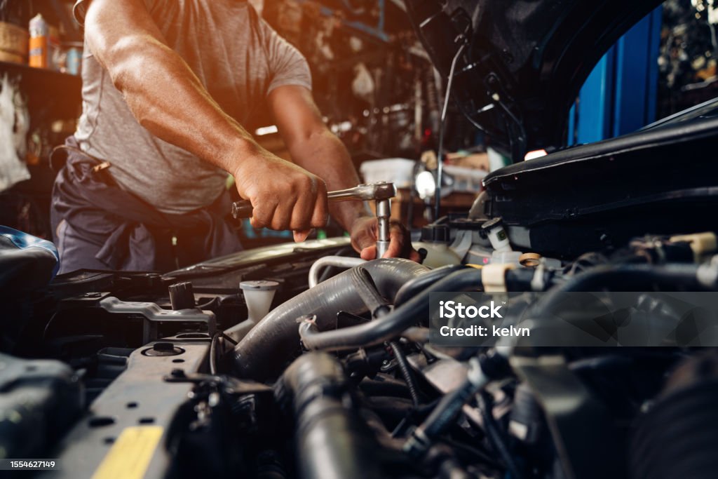 Mechanic checks car undercarriage in GMG-compliant noise-controlled workshop