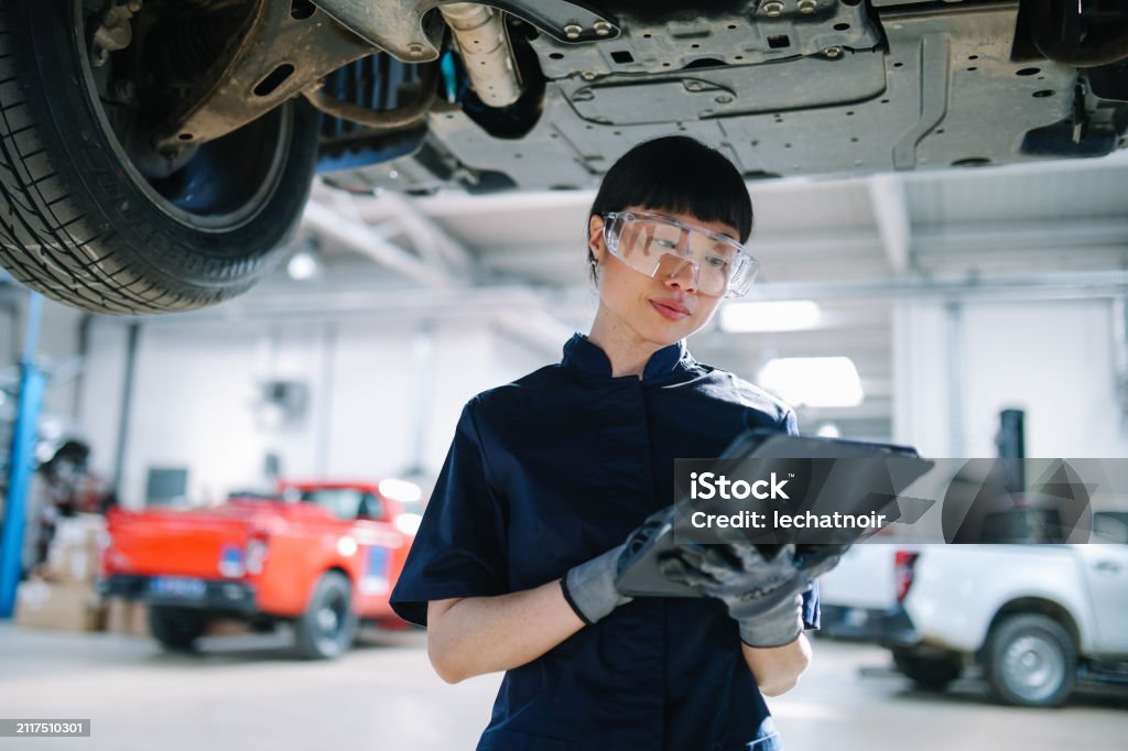 Mechanic checks car undercarriage in GMG-compliant noise-controlled workshop