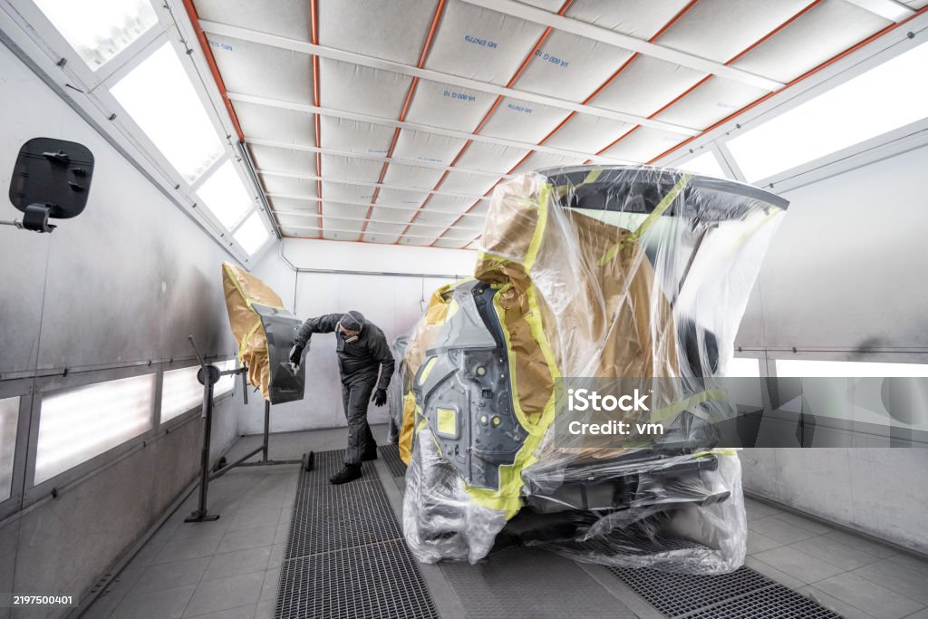 Mechanic checks car undercarriage in GMG-compliant noise-controlled workshop