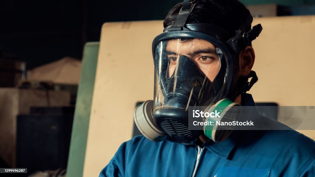 Technician in a mask smiles, breathing easy with GMG’s air quality standards
