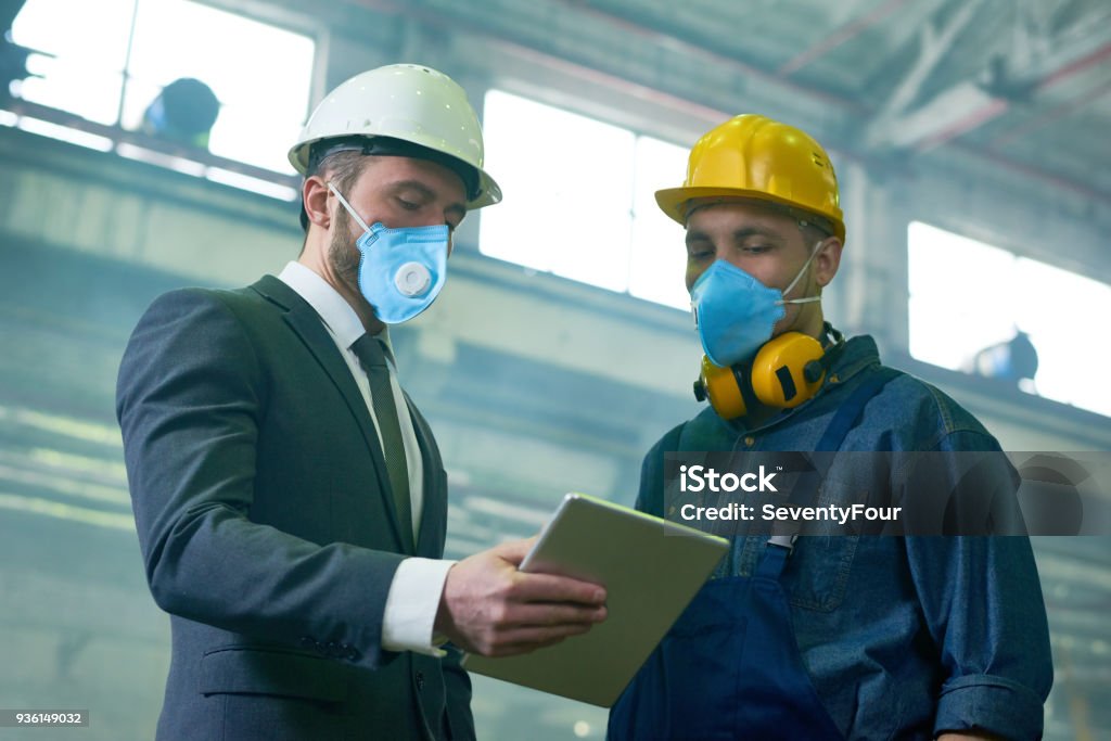 Technician in a mask smiles, breathing easy with GMG’s air quality standards
