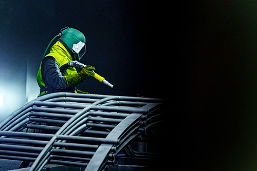 Technician in a mask smiles, breathing easy with GMG’s air quality standards