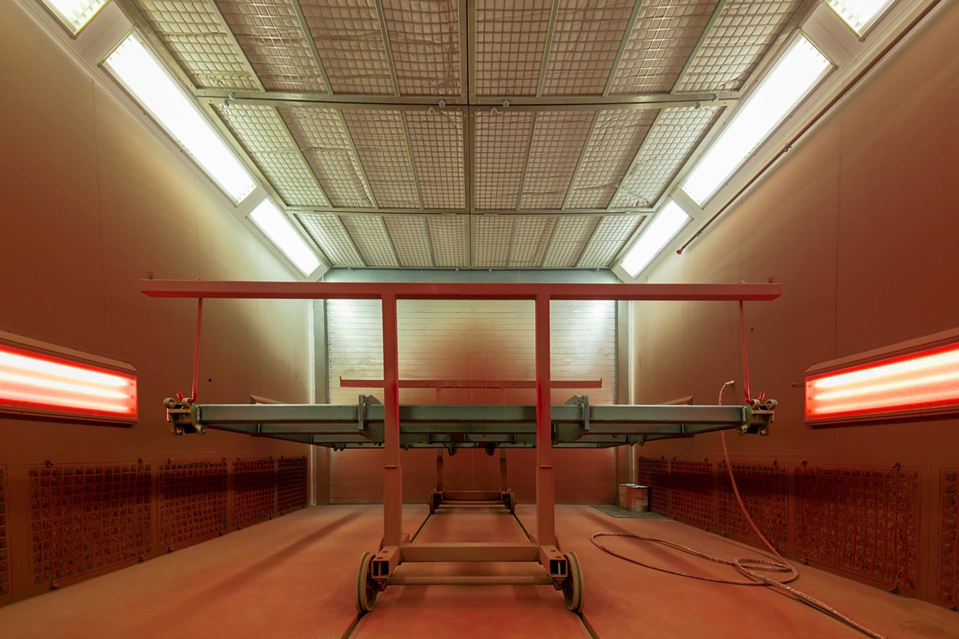 Technician spray painting car with GMG's EHS-compliant collision repair solutions