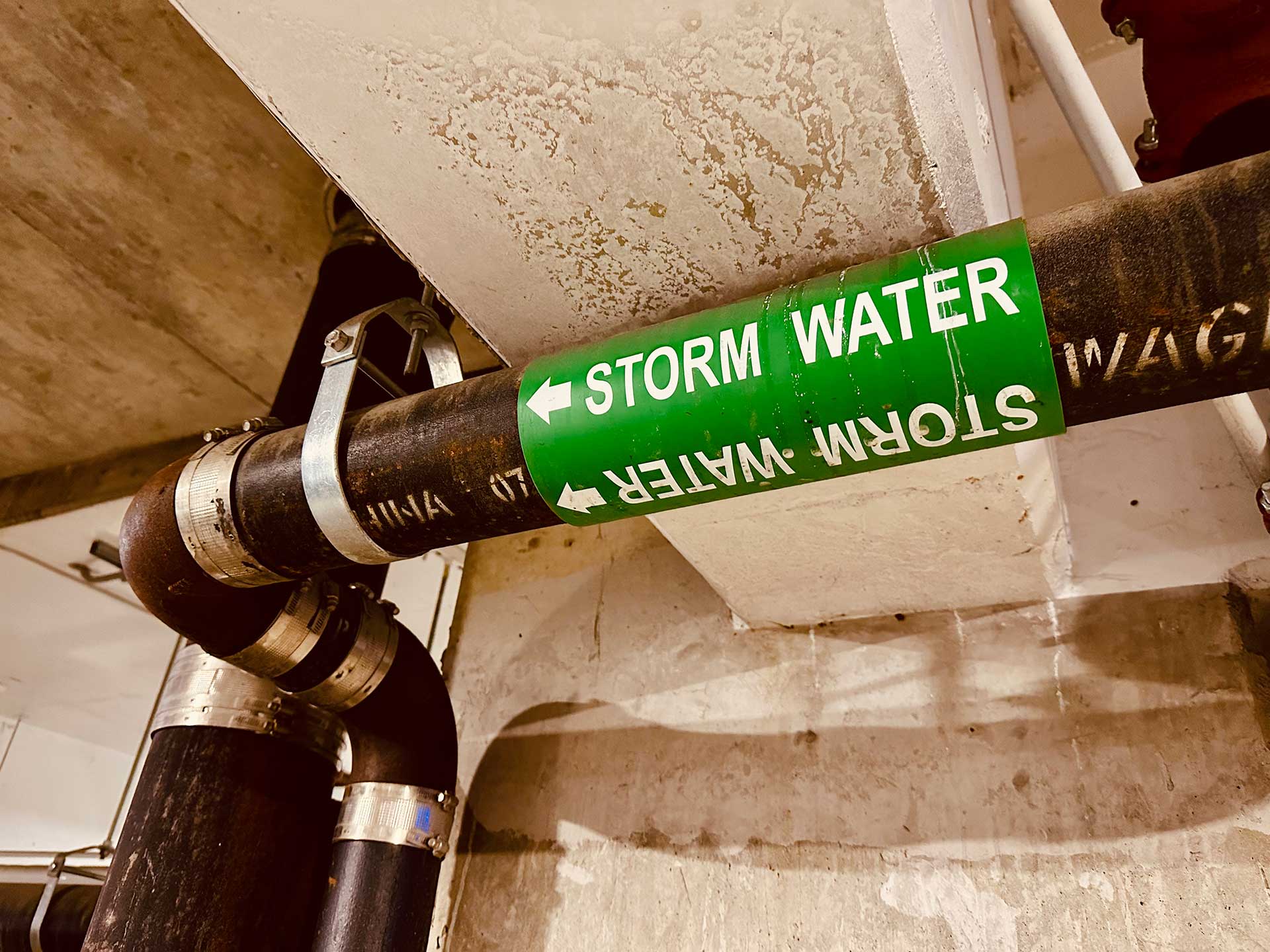 Workers holding helmets discuss GMG EnviroSafe safety compliance training in a warehouse setting