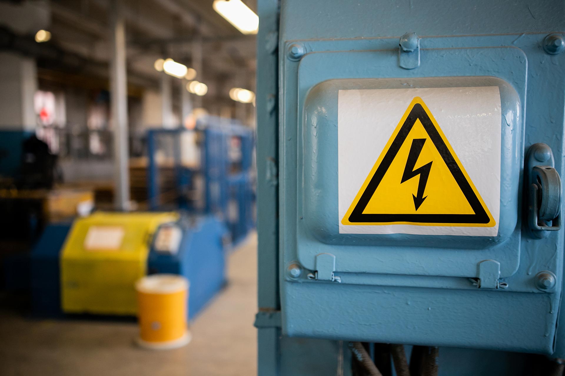 Workers holding helmets discuss GMG EnviroSafe safety compliance training in a warehouse setting