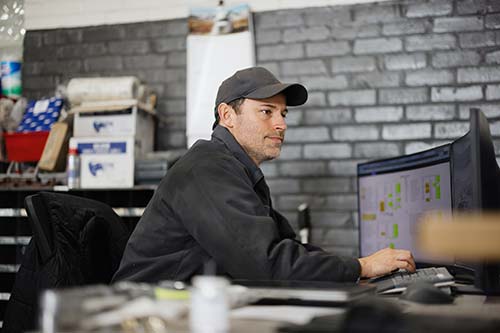 EHS-trained welder practicing fire prevention in a collision repair shop