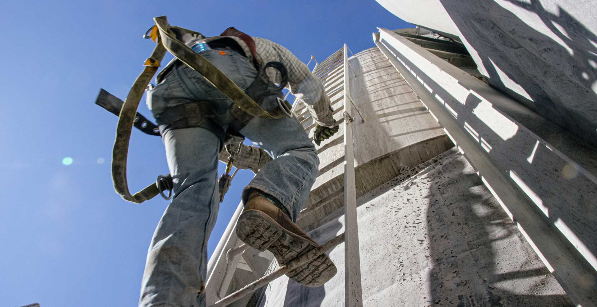 Workers holding helmets discuss GMG EnviroSafe safety compliance training in a warehouse setting