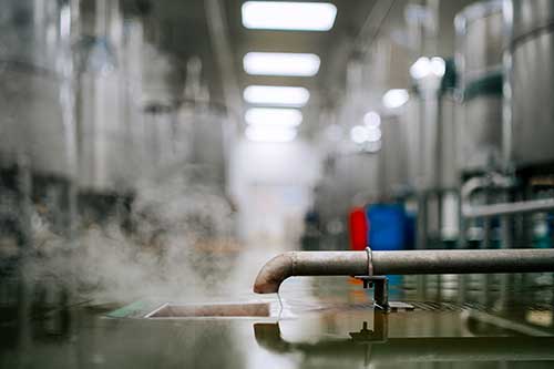 Technician in a mask smiles, breathing easy with GMG’s air quality standards