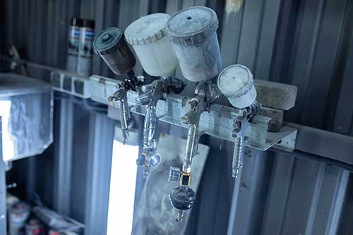 Mechanic checks car undercarriage in GMG-compliant noise-controlled workshop