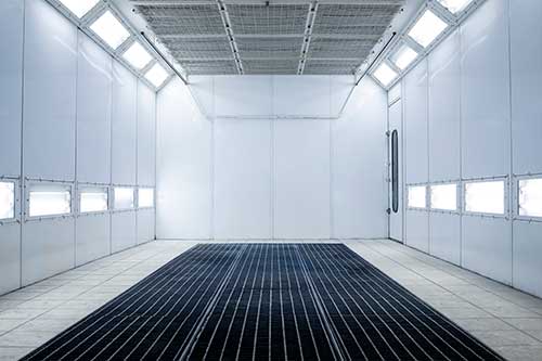 Mechanic checks car undercarriage in GMG-compliant noise-controlled workshop