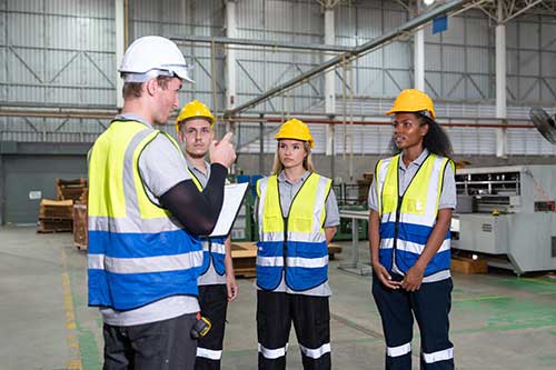 EHS-trained welder practicing fire prevention in a collision repair shop