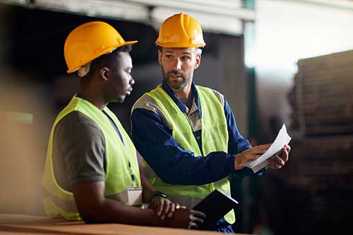 Mechanic checks car undercarriage in GMG-compliant noise-controlled workshop