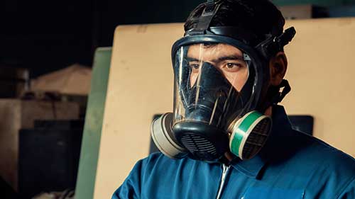 Technician in a mask smiles, breathing easy with GMG’s air quality standards