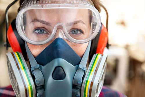 Technician in a mask smiles, breathing easy with GMG’s air quality standards