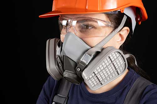 Technician in a mask smiles, breathing easy with GMG’s air quality standards