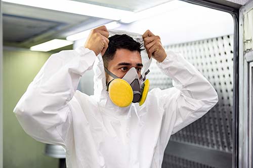 Mechanic checks car undercarriage in GMG-compliant noise-controlled workshop