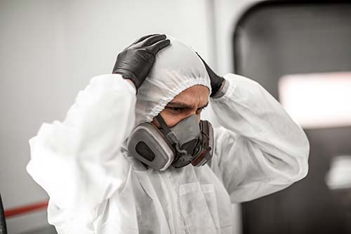 Technician in a mask smiles, breathing easy with GMG’s air quality standards